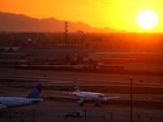 A jet arrives at sunset at Sky Harbor International Airport, Monday, July 10, 2023, in Phoenix. Phoenix is the epicenter of what may turn out to be an unprecedented extreme heat wave around the Southwest. The high temperature in the desert city has been at least 110 degrees for 11 consecutive days. Eighteen days was the longest stretch, according to the National Weather Service.