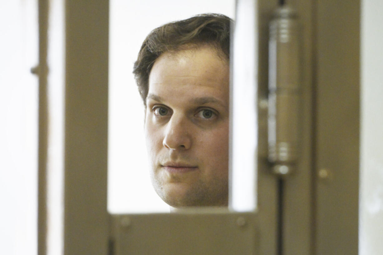 FILE - Wall Street Journal reporter Evan Gershkovich stands in a glass cage in a courtroom at the Moscow City Court in Moscow, Russia, June 22, 2023.