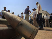 FILE - Activists and international delegations stand next to cluster bomb units, during a visit to a Lebanese military base at the opening of the Second Meeting of States Parties to the Convention on Cluster Munitions, in the southern town of Nabatiyeh, Lebanon, Sept. 12, 2011. The Biden administration has decided to provide cluster munitions to Ukraine and is expected to announce on Friday, July 6, 2023, that the Pentagon will send thousands as part of the latest military aid package for the war effort against Russia, according to people familiar with the decision.