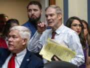 House Judiciary Committee Chair Jim Jordan, R-Ohio, center, flanked by Rep. Pete Sessions, R-Texas, left, and Rep. Lauren Boebert, R-Colo., arrives as the House Oversight and Accountability Committee holds a hearing to charge that the Justice Department interfered with a yearslong investigation into Hunter Biden, at the Capitol in Washington, Wednesday, July 19, 2023. (AP Photo/J.