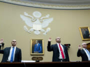 Ryan Graves, Americans for Safe Aerospace Executive Director, from left, U.S. Air Force (Ret.) Maj. David Grusch, and U.S. Navy (Ret.) Cmdr. David Fravor, are sworn in during a House Oversight and Accountability subcommittee hearing on UFOs in the House Rayburn Office building on Wednesday, July 26, 2023 in, Washington.