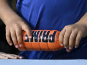 FILE - A child holds a PRIME hydration drink prior to a baseball game between the Los Angeles Dodgers and the Arizona Diamondbacks, March 31, 2023, in Los Angeles. An influencer-backed energy drink that has earned viral popularity among children is facing scrutiny from federal lawmakers and health experts over its potentially dangerous levels of caffeine. Senator Chuck Schumer on Sunday, July 9, 2023 called on the Food and Drug Administration to investigate Prime. (AP Photo/Mark J.