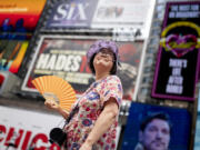 FILE - A tour guide fans herself while working in Times Square as temperatures rise, July 27, 2023, in New York. Nearly 60% of the U.S. population, are under a heat advisory or flood warning or watch as the high temperatures spread and new areas are told to expect severe storms.