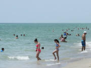 Beachgoers take a dip in the Atlantic Ocean at Hollywood Beach, on Monday in Hollywood, Fla.