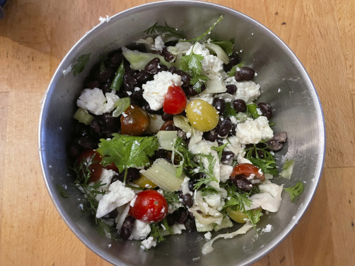 A salad made with half-can of black beans, feta cheese, celery, scallions, cilantro, cherry tomatoes and cabbage. (Beth J.