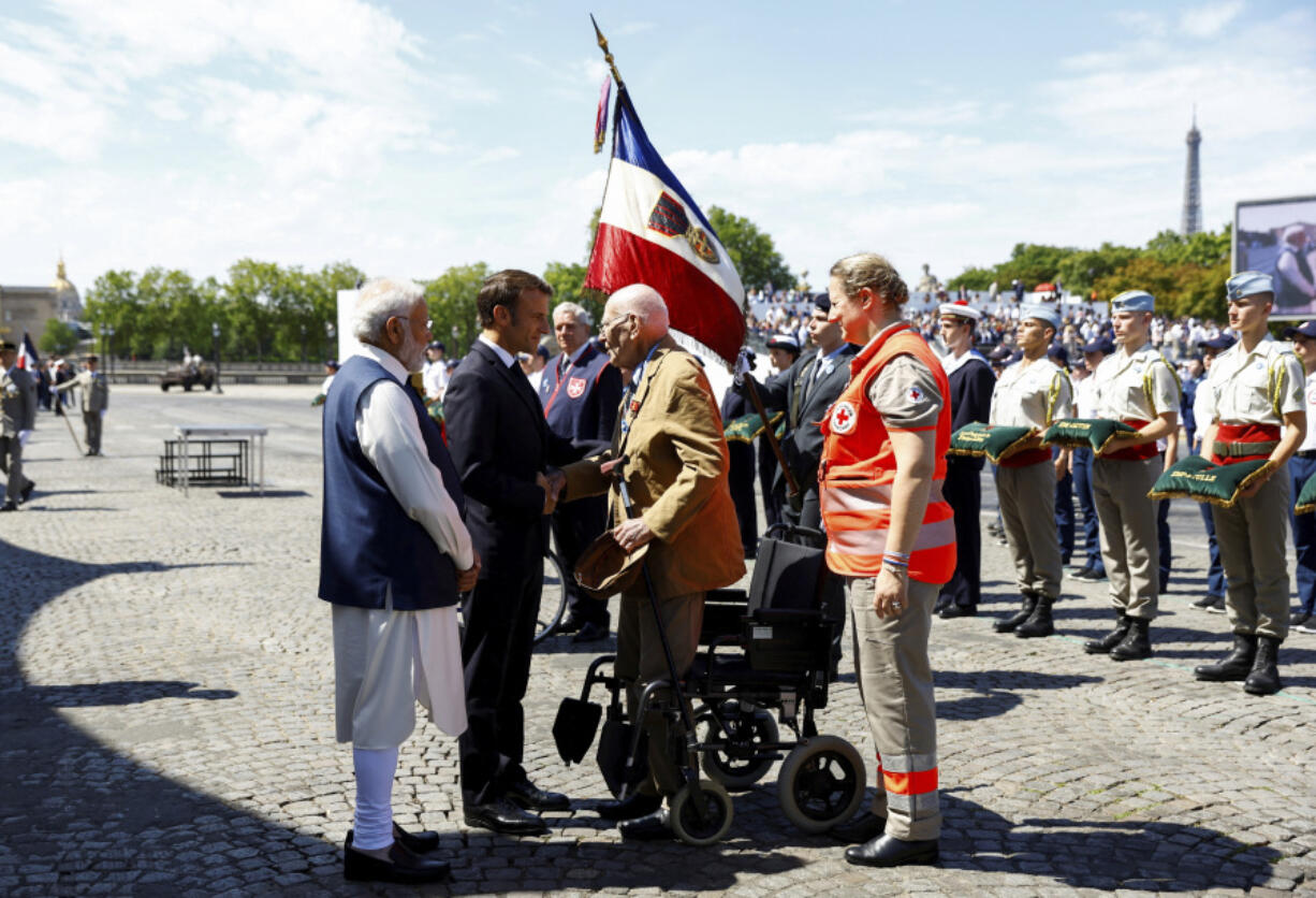 France's President Emmanuel Macron, center, and India's Prime Minister Narendra Modi meet WWII veteran Henri Becker during the annual Bastille Day military parade, in Paris, Friday, July 14, 2023. India is the guest of honor at this year's Bastille Day parade, with Prime Minister Narendra Modi in the presidential tribune alongside French President Emmanuel Macron.