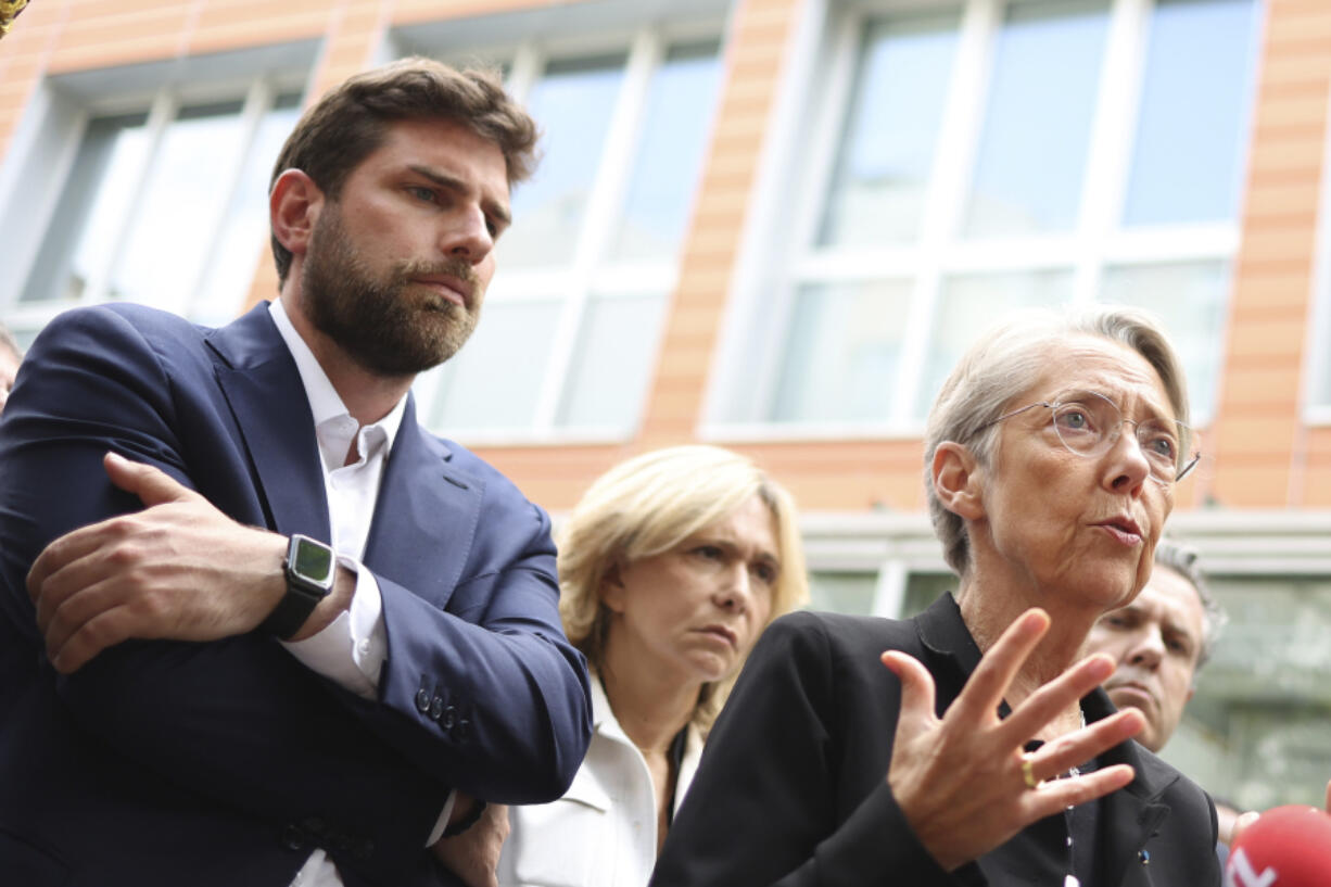 Vincent Jeanbrun, left, the Mayor of L'Hay-les-Roses, and French Prime Minister Elisabeth Borne talks to the medias after rioters rammed a vehicle into his house overnight, at the City Hall in L'Hay-les-Roses, south of Paris, Sunday, July 2, 2023. Young rioters clashed with police and targeted the mayor's home with a burning car as France saw a fifth night of unrest sparked by the police killing of a teenager.