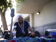 FILE - A man, who is homeless, drinks water as he wears a wet towel on his head, given to him by Maribel Padilla of the Brown Bag Coalition, July 20, 2023, in Calexico, Calif. Once temperatures hit 113 degrees Fahrenheit (45 Celsius), Padilla and the Brown Bag Coalition meet up with people who are homeless in Calexico, providing them with a cold, wet towel, and some refreshments to help them endure the scorching temperatures.