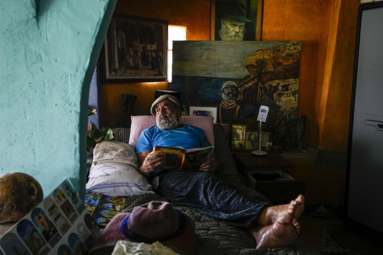 Nissim Kahlon rests in his bed in his home chiseled out of the sandstone cliffs overlooking the Mediterranean sea in Herzliya, Israel, on June 28.