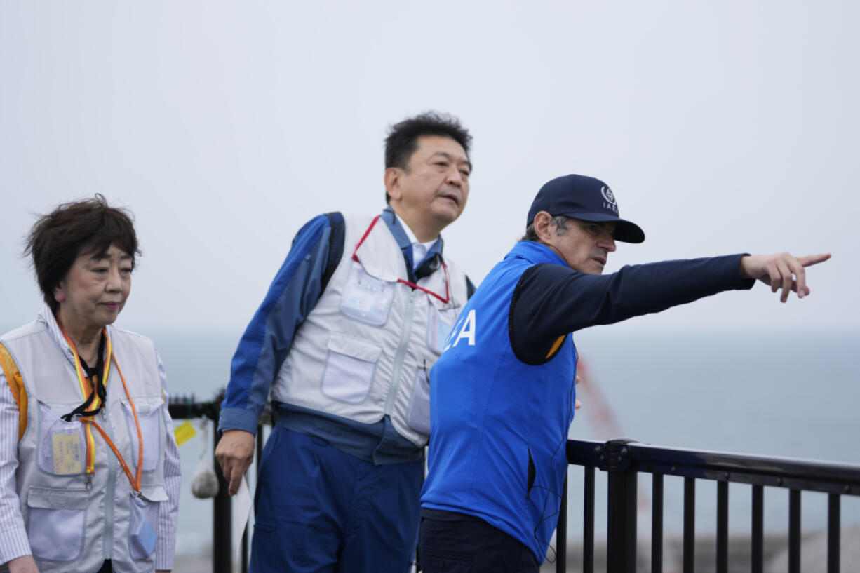 Rafael Mariano Grossi, right, Director General of the International Atomic Energy Agency, listens to Tomoaki Kobayakawa, President of Tokyo Electric Power Co., explain facilities to be used to release treated wastewater, while visiting the damaged Fukushima nuclear power plant in Futaba, northeastern Japan, Wednesday, July 5, 2023.