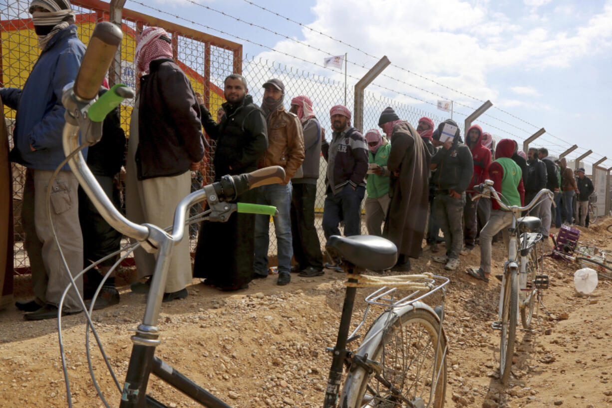 FILE - Syrian refugees line up to register their names at an employment office, Feb. 18, 2018, at the Azraq Refugee Camp, 100 kilometers (62 miles) east of Amman, Jordan.