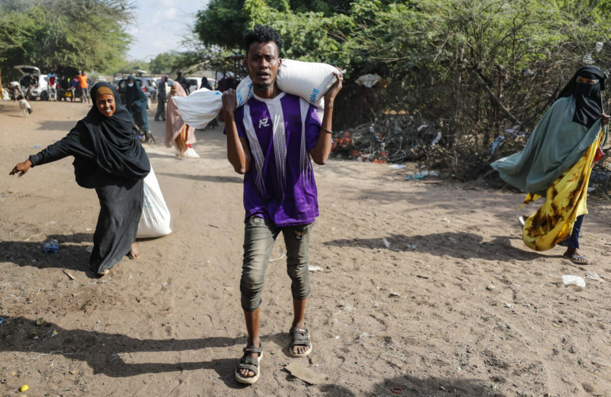 Somali refugees go home after receiving food at a food distribution center run by the World Food Programme (WFP), in Dadaab refugee camp, Kenya Thursday, July 13, 2023.