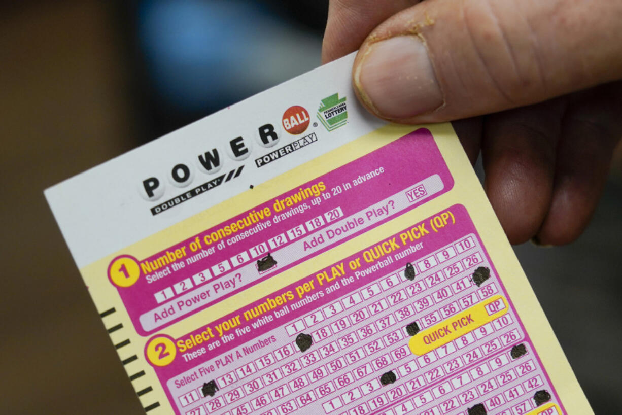 FILE - Steve Morton shows his scan card for his personal selection numbers for a ticket for a Monday Powerball drawing on Nov. 7, 2022, at a convenience store in Renfrew, Pa. The Powerball jackpot soared to an estimated $875 million after no winning ticket was sold for the Wednesday, July 12, 2023, drawing.