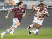 Colorado Rapids midfielder Braian Galvan, left, and Portland Timbers defender Juan David Mosquera pursue the ball in the second half of an MLS soccer match Wednesday, July 12, 2023, in Commerce City, Colo. The first half of the match was played Tuesday, July 4, before it was delayed by a rainstorm and rescheduled for Wednesday, July 12.