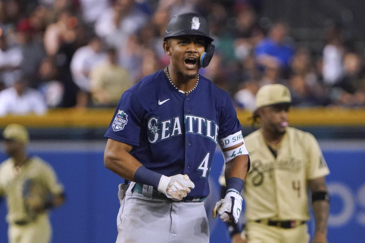 Seattle Mariners Julio Rodriguez gestures toward the team's dugout after hitting a double against the Arizona Diamondbacks during the ninth inning of a baseball game Friday, July 28, 2023, in Phoenix.