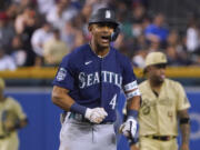 Seattle Mariners Julio Rodriguez gestures toward the team's dugout after hitting a double against the Arizona Diamondbacks during the ninth inning of a baseball game Friday, July 28, 2023, in Phoenix.