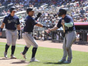 Seattle Mariners' Dylan Moore (25) celebrates with Ty France (23) after Moore hit a home run during the fifth inning of a baseball game against the Minnesota Twins, Wednesday, July 26, 2023, in Minneapolis.