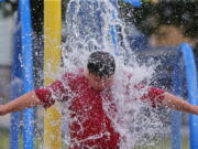 Graiden Therrien, 11, cools off in a water feature Monday at Harrington Park in New Bedford, Mass., amid sweltering heat.