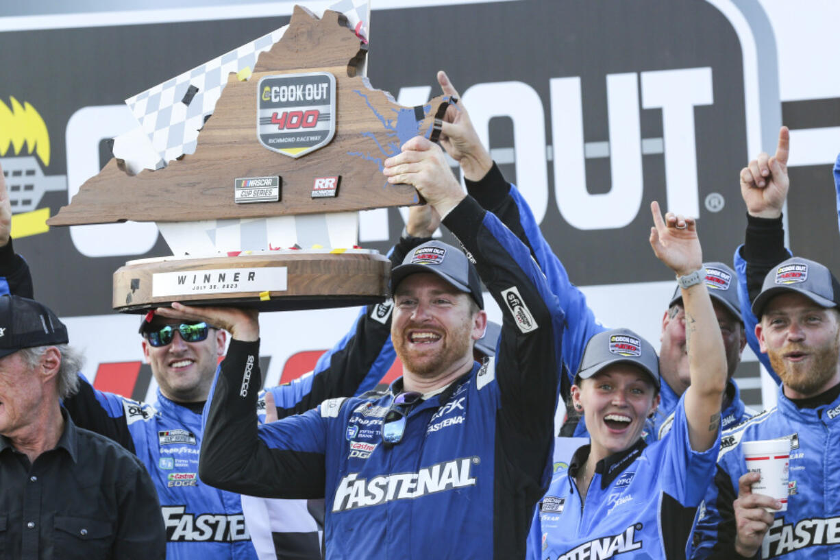 Chris Buescher raises the Cook Out 400 Trophy in Victory Lane after winning a NASCAR Cup Series auto race, Sunday, July 30, 2023, in Richmond, Va.