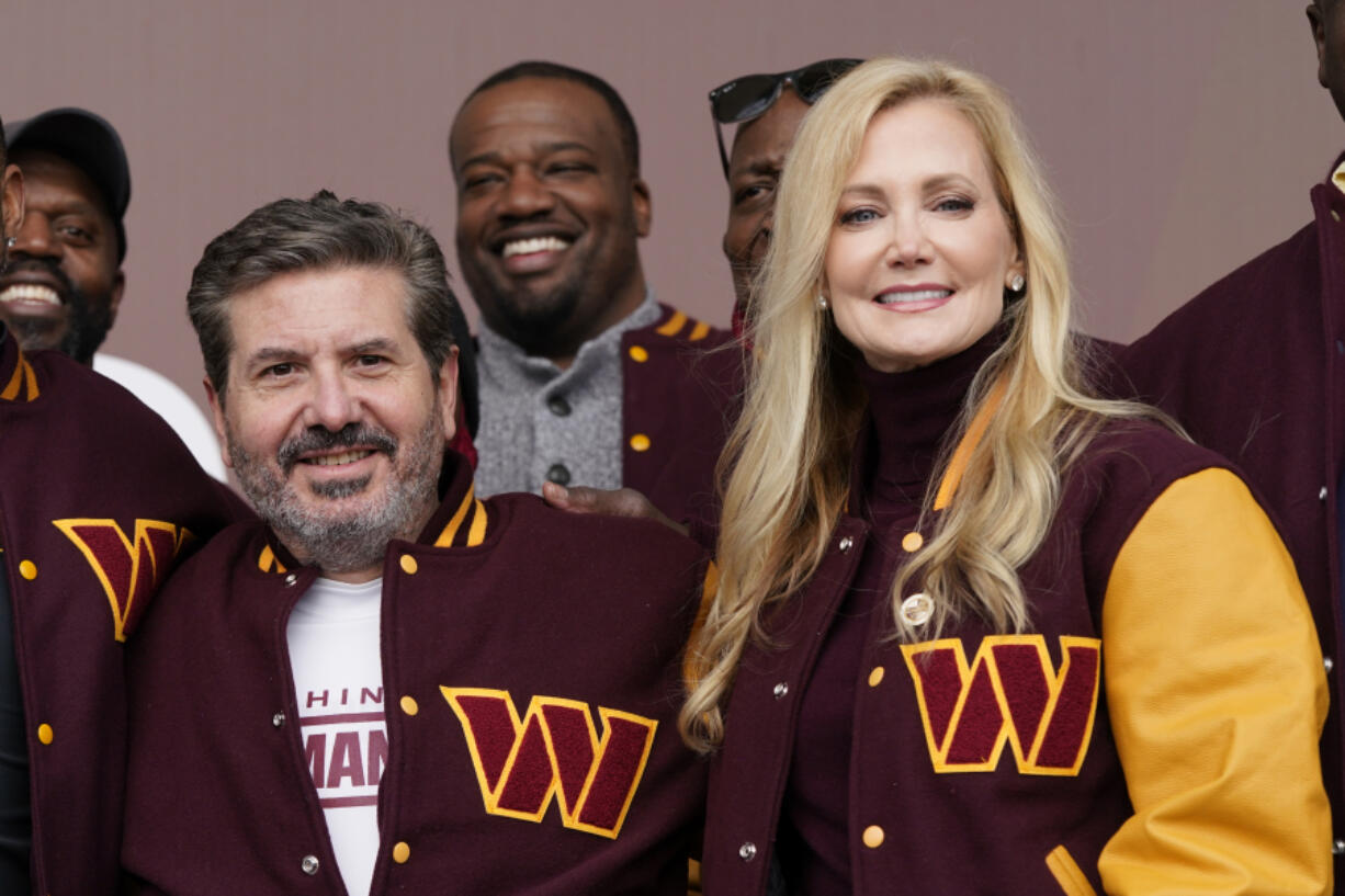 FILE - Dan and Tanya Snyder, co-owner and co-CEOs of the Washington Commanders, pose for photos after unveiling their NFL football team's new identity, Wednesday, Feb. 2, 2022, in Landover, Md. NFL owners unanimously approved the sale of the Washington Commanders on Thursday, July 2023, from Dan Snyder to a group led by Josh Harris and including Magic Johnson for a record $6.05 billion.