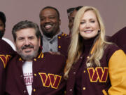 FILE - Dan and Tanya Snyder, co-owner and co-CEOs of the Washington Commanders, pose for photos after unveiling their NFL football team's new identity, Wednesday, Feb. 2, 2022, in Landover, Md. NFL owners unanimously approved the sale of the Washington Commanders on Thursday, July 2023, from Dan Snyder to a group led by Josh Harris and including Magic Johnson for a record $6.05 billion.