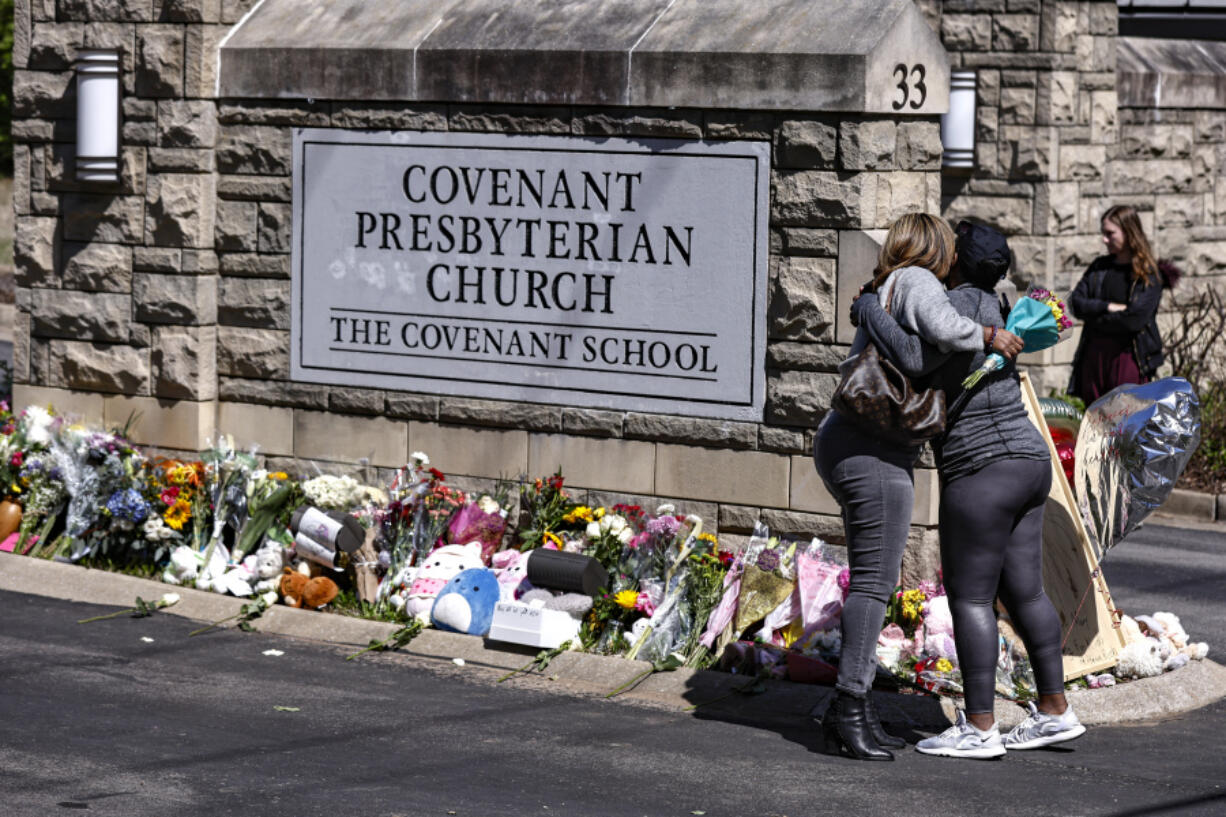 FILE - Two women hug at a memorial at the entrance to The Covenant School on Wednesday, March 29, 2023, in Nashville, Tenn. In Tennessee, a request for police to release a school shooter's private writings has morphed into a complex multiparty legal fight. With no national standard over how to treat such records, both sides claim their position is in the public interest.