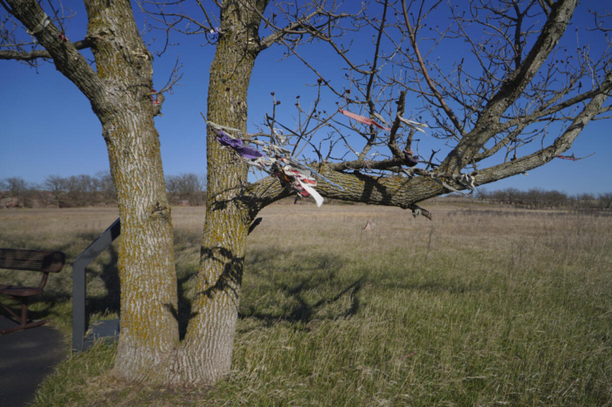 Strips of cloth and pouches of tobacco and sage, hung as offerings made by Indigenous people in prayer, blow in the wind at Pipestone National Monument in Pipestone, Minn.