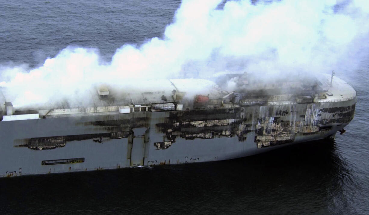 Smoke is seen from a freight ship in the North Sea, about 27 kilometers (17 miles) north of the Dutch island of Ameland, Friday, July 28, 2023. Salvage crews were waiting Friday for a chance to board a cargo ship loaded with cars that has been burning for more than two days off the northern Dutch coast.