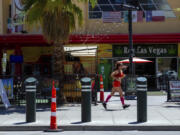 A person jogs on the Las Vegas strip during a heat advisory, Friday, July 14, 2023 in Las Vegas. Nearly a third of Americans were under extreme heat advisories, watches and warnings Friday, including in Las Vegas as a high pressure dome moves west from Texas.