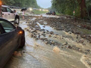 Vehicles come to a standstill near a washed-out and flooded portion of the Palisades Parkway just beyond the traffic circle off the Bear Mountain Bridge, Sunday, July 9, 2023, in Orange County, N.Y. Heavy rain spawned extreme flooding in New York's Hudson Valley that killed at least one person, swamped roadways and forced road closures on Sunday night, as much of the rest of the Northeast U.S. geared up for a major storm.