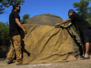 Men work to build a sweat lodge June 3 on Oak Flat Campground, a sacred site for Native Americans, in Miami, Ariz. Resolution Copper Mining, a joint subsidiary of British and Australian mining giants, Rio Tinto and BHP, has proposed a massive copper mine on the flats.