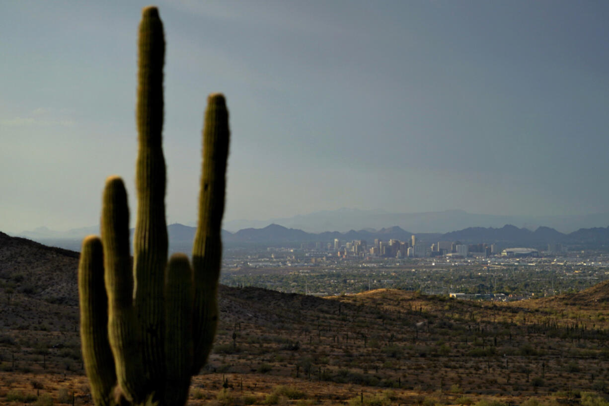 The sun sets over Phoenix, Sunday, July 30, 2023. Phoenix sizzled through its 31st consecutive day of at least 110 degrees Fahrenheit (43.3 Celsius) and other parts of the country grappled Sunday with record temperatures after a week that saw significant portions of the U.S. population subject to extreme heat.