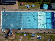 People spend time in a public pool in Wehrheim near Frankfurt, Germany, on a hot Saturday, July 8, 2023.