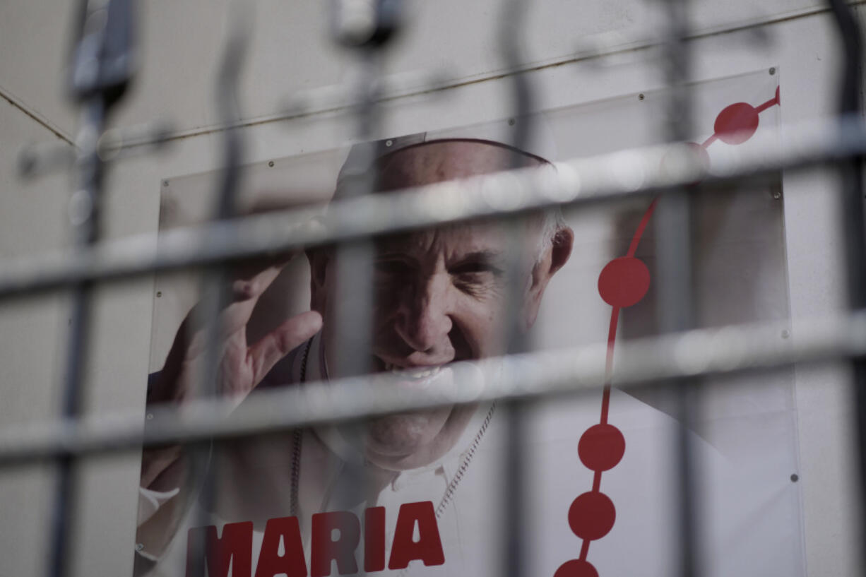 A poster showing a picture of Pope Francis and announcing World Youth Day 2023 hangs outside a church in Lisbon, Tuesday, July 25, 2023. Pope Francis is going on a five-day visit next week to Portugal, where a scandal that erupted earlier this year over Catholic Church sex abuse is still simmering, to attend international World Youth Day.