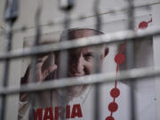 A poster showing a picture of Pope Francis and announcing World Youth Day 2023 hangs outside a church in Lisbon, Tuesday, July 25, 2023. Pope Francis is going on a five-day visit next week to Portugal, where a scandal that erupted earlier this year over Catholic Church sex abuse is still simmering, to attend international World Youth Day.