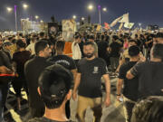 Protesters gather in Baghdad's Tahrir Square, carrying Iraqi flags and images of influential Iraqi Shiite cleric and political leader Muqtada al-Sadr, Saturday, July 22, 2023, following reports of the burning of a Quran carried out by a ultranationalist group in front of the Iraqi Embassy in Copenhagen. Protesters attempted to cross the Jumhuriya bridge leading to the Green Zone, where the Danish embassy is, but were pushed back by security forces.