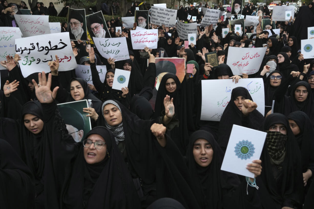 Protesters chant slogans against Sweden in front of the embassy in Tehran, Iran, Friday, July 21, 2023. Thousands of people took to the streets in a handful of Muslim-majority countries Friday to express their outrage at the desecration of a copy of the Quran in Sweden, a day after protesters stormed the country's embassy in Iraq. The placard at left reads in Farsi: " Our red lines are the supreme leader and the Quran".