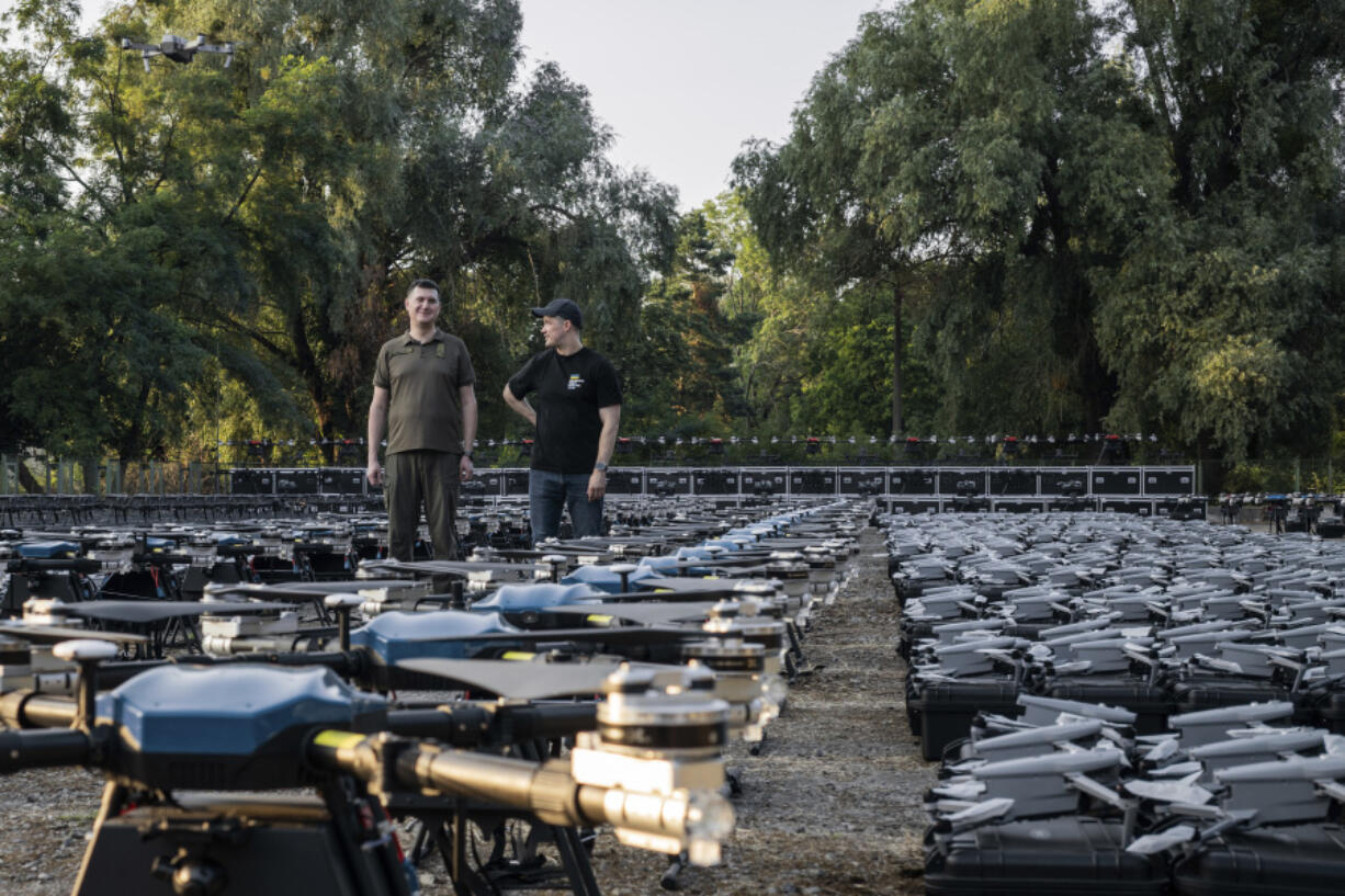 Mykhailo Fedorov, Ukrainian minister of digital transformation, right, and Yuriy Shchygol, head of State Special Communications Service, pose for a photo next to 1700 drones that are being sent to the frontline to be used against Russian forces, in Kyiv, Ukraine, Tuesday, July 25, 2023.