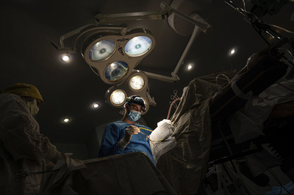 Neurosurgeon Nikita Lombrozo operates on a patient who sustained a shrapnel injury on the left part of the brain, at  Mechnikov Hospital in Dnipro, Ukraine, Friday, July 14, 2023. A surge of wounded soldiers has coincided with the major counteroffensive Ukraine launched last month to try to recapture its land from Russian forces. Surgeons at Mechnikov Hospital, one of the country's biggest, are busier now than perhaps at any other time since Russia began its invasion 17 months ago.