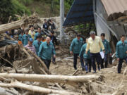 South Korean President Yoon Suk Yeol, third from left, looks around a flood damaged area in Yecheon, South Korea, Monday, July 17, 2023. Heavy downpours lashed South Korea a ninth day on Monday as rescue workers struggled to search for survivors in landslides, buckled homes and swamped vehicles in the most destructive storm to hit the country this year.