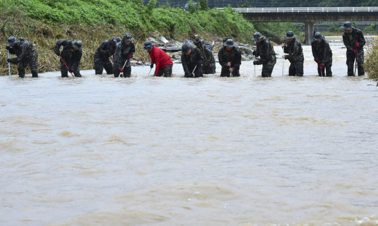 South Korean marines search for missing people in floodwaters in Yecheon, South Korea, Tuesday, July 18, 2023. Rescuers continued their searches Tuesday for people still missing in landslides and other incidents caused by more than a week of torrential rains.