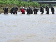 South Korean marines search for missing people in floodwaters in Yecheon, South Korea, Tuesday, July 18, 2023. Rescuers continued their searches Tuesday for people still missing in landslides and other incidents caused by more than a week of torrential rains.