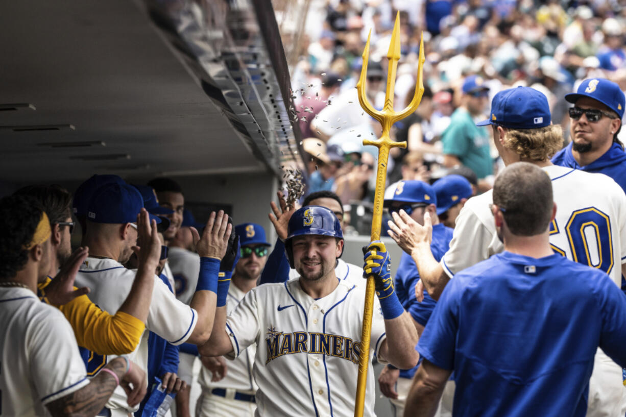 Seattle Mariners' Cal Raleigh celebrates in the dugout after hitting a solo home run off Detroit Tigers starting pitcher Reese Olson during the fourth inning of a baseball game, Sunday, July 16, 2023, in Seattle.