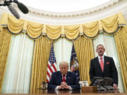 FILE - Pastor Robert Jeffress and President Donald Trump pray after Trump signed a full pardon for Alice Johnson in the Oval Office of the White House, Friday, Aug. 28, 2020, in Washington. Jeffress, pastor of an evangelical megachurch in Dallas, has been a staunch supporter of Trump since his first campaign for president. "Conservative Christians continue to overwhelmingly support Donald Trump because of his biblical policies, not his personal piety," Jeffress told The Associated Press via email.