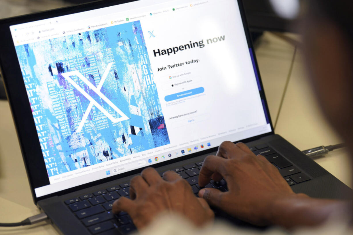 A person poses for a photo signing into the Twitter website which is now displaying the new logo for Twitter, in an office in central London, Monday July 24, 2023. Elon Musk has unveiled a new "X" logo to replace Twitter's famous blue bird as he follows through with a major rebranding of the the social media platform he bought for $44 billion last year. Musk had asked fans for logo ideas and chose one, which he described as minimalist Art Deco, saying it "certainly will be refined.