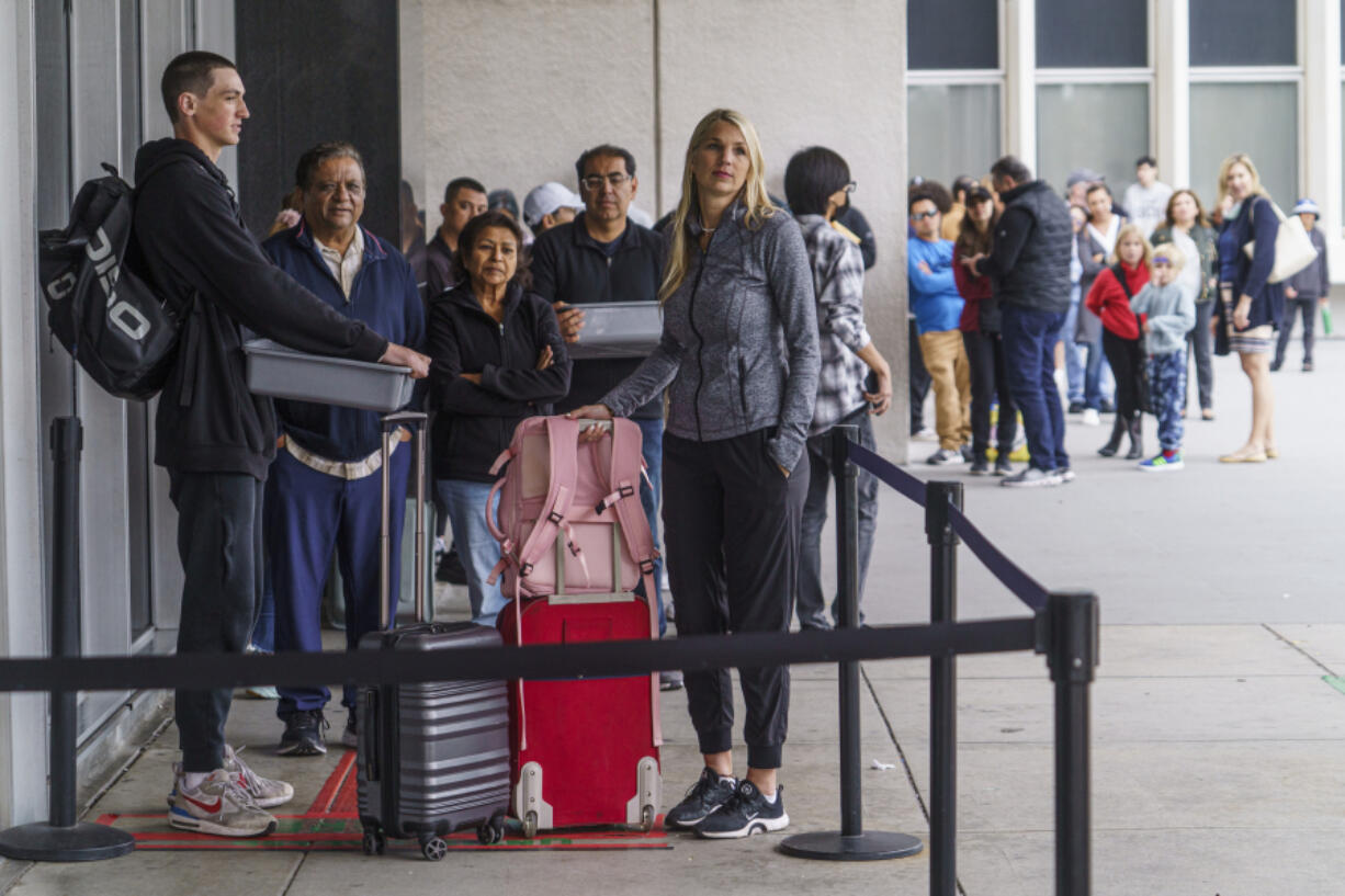 Marni Larsen and her son, Damon Rasmussen, of Holladay, Utah, wait their turn in line June 14 hoping to snag her son's passport outside the Los Angeles Passport Agency at the Federal Building in Los Angeles. Larsen applied for her son's passport two months earlier and spent weeks checking for updates online or through a frustrating call system.