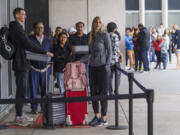 Marni Larsen and her son, Damon Rasmussen, of Holladay, Utah, wait their turn in line June 14 hoping to snag her son's passport outside the Los Angeles Passport Agency at the Federal Building in Los Angeles. Larsen applied for her son's passport two months earlier and spent weeks checking for updates online or through a frustrating call system.