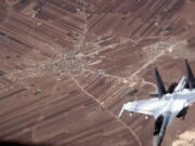 In this image from video released by the U.S. Air Force, a Russian SU-35 flies near a U.S. Air Force MQ-9 Reaper drone on Wednesday, July 5, 2023, over Syria. The U.S. Air Force says Russian fighter jets flew dangerously close to several U.S. drone aircraft over Syria, setting off flares and forcing the MQ-9 Reapers to take evasive maneuvers. (U.S.