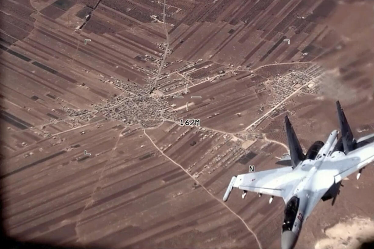 FILE - In this image from video released by the U.S. Air Force, a Russian Su-35 flies near a U.S. Air Force MQ-9 Reaper drone on July 5, 2023, over Syria. U.S. officials say that a Russian fighter jet flew very close to a manned U.S. surveillance aircraft over Syria Sunday, July 16, forcing it to go through the turbulent wake and putting the lives of the four-person American crew in danger.(U.S.