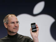 Apple CEO Steve Jobs holds up an Apple iPhone at the MacWorld Conference on Jan. 9, 2007, in San Francisco.